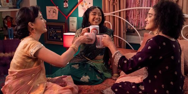 Maitreyi Ramakrishnan as Devi Vishwakumar, Lee Rodriguez as Fabiola Torres and Ramona Young as Eleanor Wong cl<em></em>inking glasses in Never Have I Ever season 4 episode 10.