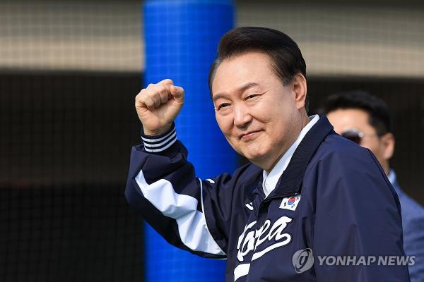 President Yoon Suk Yeol fist pumps the audience after watching a children's ba<em></em>seball game at a sports park in Seoul on April 6 2024, in this photo provided by Yoon's office. (PHOTO NOT FOR SALE) (Yonhap)