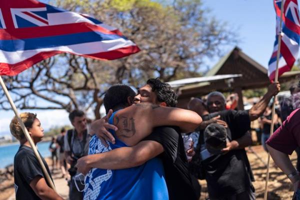 Residents of the historic Maui town of Lahaina, who are affected by a deadly wildfire that devastated the community, hug one another after a news co<em></em>nference on Friday, Aug. 18, 2023.
