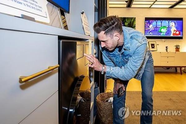 A man takes a look at Samsung Electro<em></em>nics Co.'s new home appliance product, Bespoke AI, during a media event in New York on April 3, 2024, in this photo provided by the company. (PHOTO NOT FOR SALE) (Yonhap)