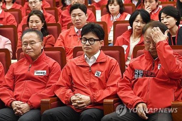 Officials of the ruling People Power Party, including its interim leader Han Dong-hoon (C, front row), look gloomy at the Natio<em></em>nal Assembly in Seoul on April 10, 2024, as TV exit polls of the general elections to choose 300 lawmakers project its devastating defeat to the main opposition Democratic Party. (Pool photo) (Yonhap)