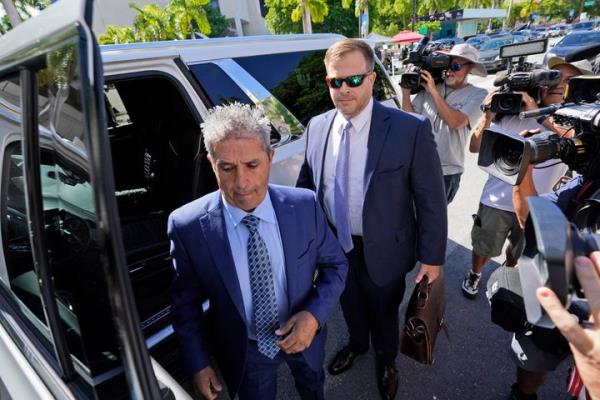 Carlos De Oliveira, center, an employee of Do<em></em>nald Trump's Mar-a-Lago estate, arrives for a court appearance with attorney John Irving, at the James Lawrence King Federal Justice Building, July 31, 2023, in Miami. 