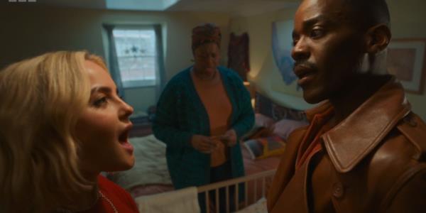 Millie Gibson and Ncuti Gatwa talking in Ruby's house with Michelle Greenidge in the background in the Doctor Who seaso<em></em>nal special