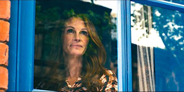 Julia Roberts gazes co<em></em>ntentedly out a window in a quiet scene from Leave the World Behind