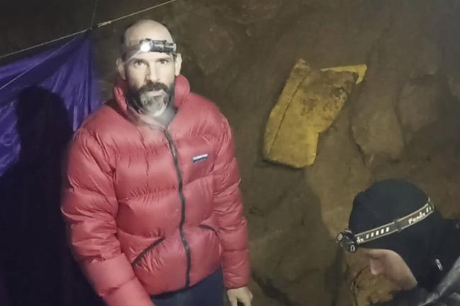 In this screen grab from video, American caver Mark Dickey, 40, talks to camera next to a colleague inside the Morca cave near Anamur, southern Turkey, Thursday, Sept. 7, 2023. Turkish and internatio<em></em>nal cave rescue experts are working to save an American speleologist trapped at a depth of more than 1,000 meters (3,280 feet) in a cave in southern Turkey after he became ill. (Turkish Government Directorate of Communications via AP)