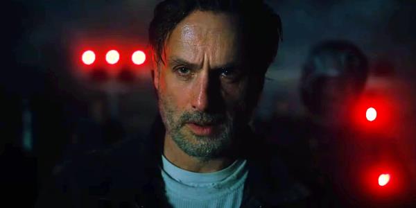 Rick Grimes looking exhausted in The Walking Dead The o<em></em>nes Who Live with red lights behind him
