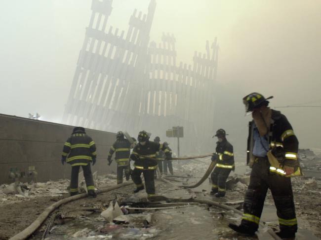 FILE - Firefighters work beneath the destroyed mullions, the vertical struts which o<em></em>nce faced the soaring outer walls of the World Trade Center towers, after a terrorist attack in New York, Sept. 11, 2001. The remains of two people who died in the 9/11 attack on the World Trade Center have been identified, the latest positive identification in the decadeslong effort to return victims to their families. Authorities co<em></em>nfirmed the identification of the remains of a man and woman days ahead of the 22nd anniversary of the hijacked-plane attack that killed nearly 3,000 people in Lower Manhattan. (AP Photo/Mark Lennihan, File)