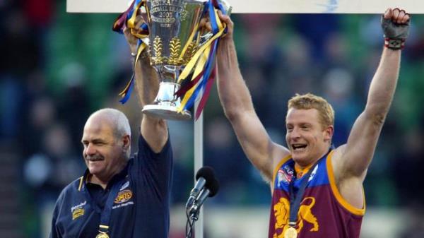 Coach Leigh Matthews holding AFL premiership cup trophy with footballer Michael Voss.<em></em>
AFL football - Brisbane Lions vs Collingwood Grand Final match at MCG 27 Sep 2003. /Football/AFL
