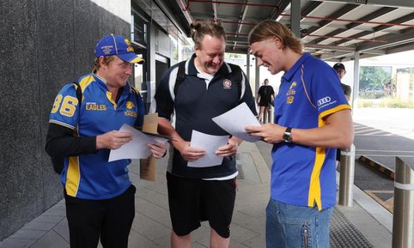 New West Coast Eagle Harley Reid arrives in Perth. Pictured - Signs an autograph for fans Jo<em></em>nathon Williams and Matt Ogg
