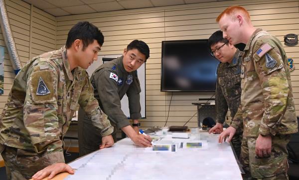 Military perso<em></em>nnel of the South Korean Air Force's Space Operation Squadron and the United States Space Forces Korea analyze coordinates of jamming attacks during joint training exercises held at an air ba<em></em>se in Gunsan, 178 kilometers south of Seoul, on April 22, 2024, in this photo provided by the Air Force. (PHOTO NOT FOR SALE) (Yonhap) 
