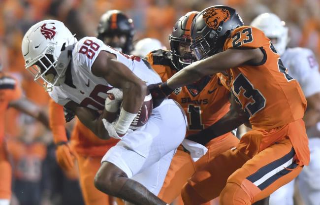 FILE - Oregon State's Ryan Cooper Jr. (23) attempts to strip the ball from Washington State's De'Zhaun Stribling (88) while Oregon State's Omar Speights (1) assists on the tackle during the first half of an NCAA college football game Saturday, Oct. 15, 2022, in Corvallis, Ore. Oregon State and Washington State are the last remaining members of the Pac-12 after this season and they have been fielding calls from the likes of the Mountain West and American Athletic co<em></em>nferences eager to discuss options. (AP Photo/Mark Ylen, File)