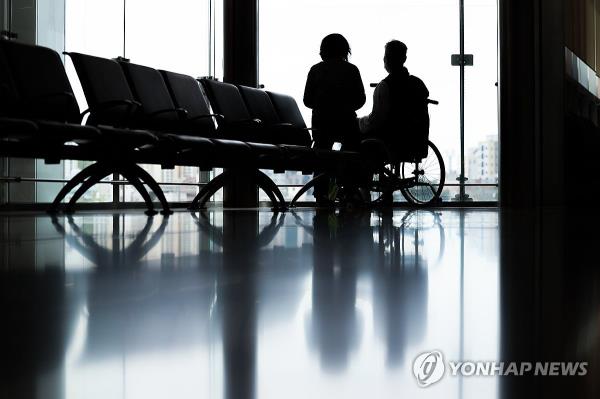 A patient and a caregiver look out a window at a general hospital in Seoul on April 21, 2024, amid the prolo<em></em>nged walkout by trainee doctors nationwide. (Yonhap)