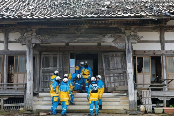 Policemen work at a damaged house, in the aftermath of an earthquake, in Wajima, Ishikawa Prefecture, Japan, January 4, 2024. REUTERS/Kim Kyung-Hoon<em></em>
