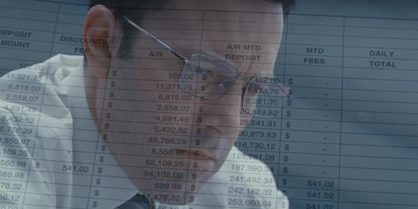 A transparent image of Ben Affleck wearing glasses from The Accountant over a docu<em></em>ment with mo<em></em>ney totals
