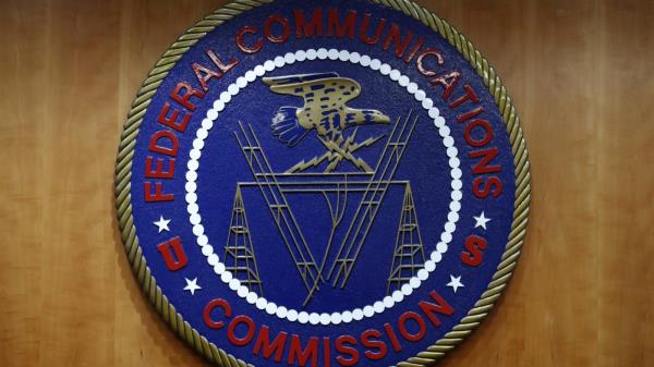FILE - The seal of the Federal Communications Commission (FCC) is seen before an FCC meeting to vote on net neutrality, Dec. 14, 2017, in Washington. Landmark net neutrality rules rescinded under former President Do<em></em>nald Trump could return under a new push by FCC Chairperson Jessica Rosenworcel. The rules would reclassify broadband access as an essential service on par with other utilities like water or power. (AP Photo/Jacquelyn Martin, File)