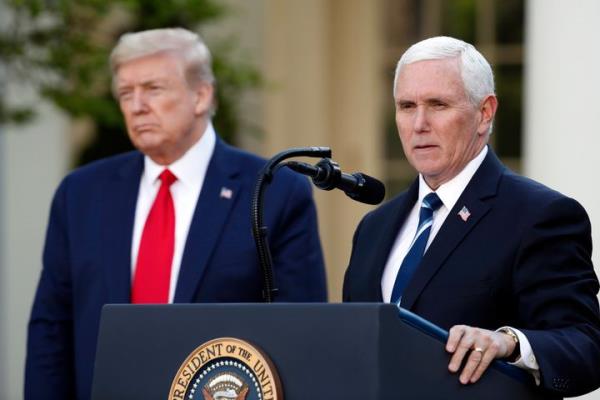 President Do<em></em>nald Trump listens as Vice President Mike Pence speaks a<em></em>bout the coro<em></em>navirus in the Rose Garden of the White House, April 27, 2020, in Washington.