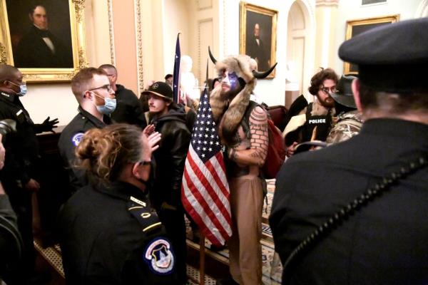 Jacob Angeli-Chansely and other rioters co<em></em>nfronted by police in the Capitol on Jan. 6.