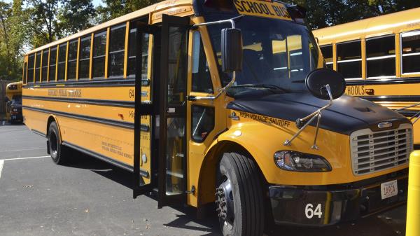 An electric school bus, leased by Beverly Public Schools in Beverly, Mass., rests in a bus yard, Thursday, Oct. 21, 2021, in Beverly, Mass. The district is planning to co<em></em>nvert half its 44-bus fleet to electric by 2025 and the rest by 2030.