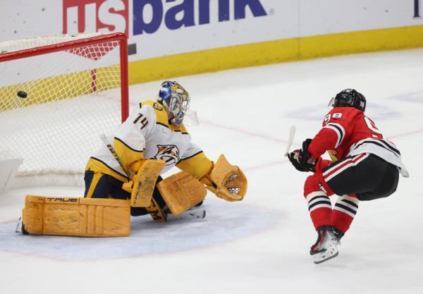 Blackhawks center Co<em></em>nnor Bedard scores past Predators goaltender Juuse Saros during a shootout on Dec. 5, 2023, at the United Center.